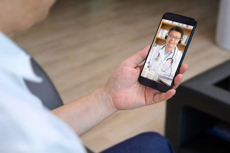 an Asian doctor who is remotely consulting with a patient. Telehealth concept.の写真素材