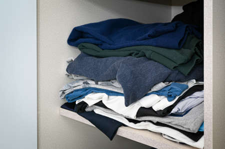 Clothes messy piled up on the closet shelfの写真素材