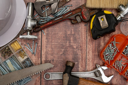 On a wooden board, a variety of tools needed for home repair are irregularly placed.の写真素材