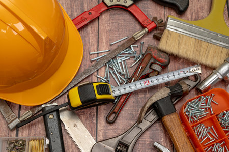 On a wooden board, a variety of tools needed for home repair are irregularly placed.の写真素材
