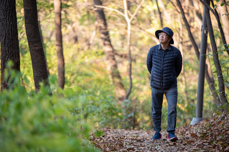 A man walking barefoot on a fallen leafy road. Healthy lifestyle conceptの写真素材