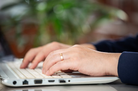 Hands of a middle-aged man using a laptopの写真素材