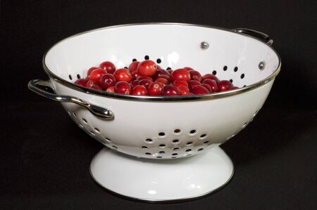 fresh, washed cranberries in white colanderの写真素材