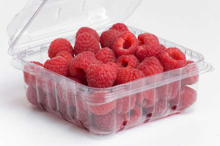 fresh, red raspberries in plastic fruit containerの写真素材