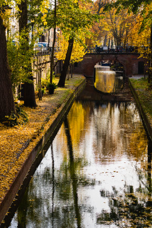 Autumn trees and a bridge over a canal in the historic city centre of Utrecht, the Netherlandsの写真素材