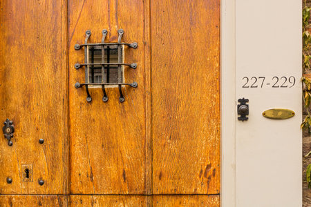 Peephole, doorbell and house numbers at old wooden front door, Utrecht, the Netherlandsの写真素材