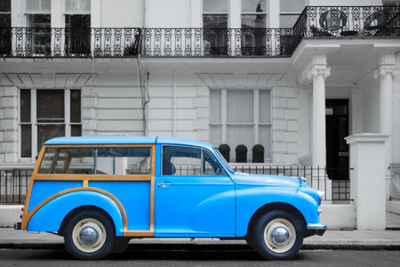 British blue oldtimer from 50s or 60s in front of white Victorian facades, London, UK