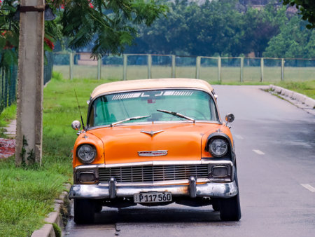 Orange coloured oldtimer parked on the street, Cuba
