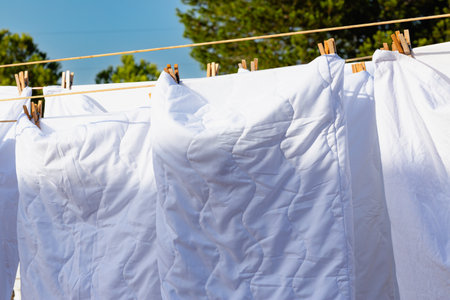 Murcia, Spain - 12th August 2024 - White laundry drying in sunlight against a clear blue sky, creating a vibrant atmosphere during a summer dayの写真素材