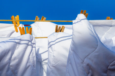 Murcia, Spain - 12th August 2024 - White laundry drying in sunlight against a clear blue sky, creating a vibrant atmosphere during a summer dayの写真素材
