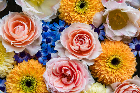Flower arrangement of pink roses and yellow mums floating on the waterの写真素材