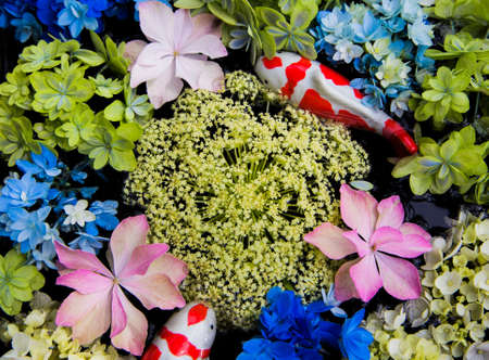 Ceramic fish, hydrangea and Queen Anneâs lace floating in waterの写真素材