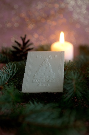 Christmas wafer on spruce branches, in  background candleの写真素材