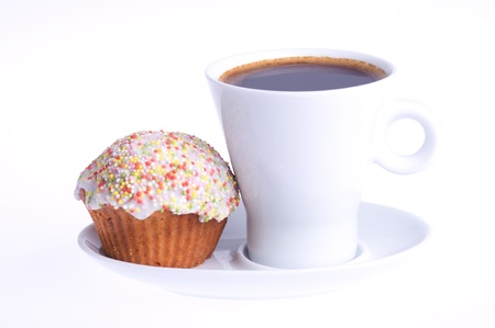 coffee with a cupcake with sprinkles on a saucer on a white backgroundの写真素材