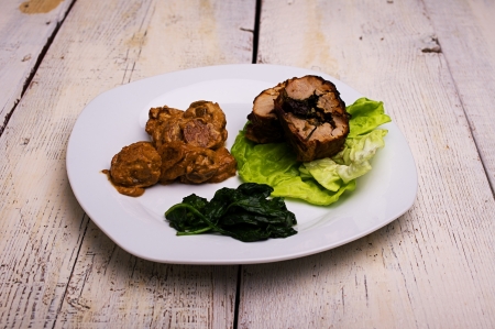loin stuffed with spinach and roasted potatoes in cream sauceの写真素材