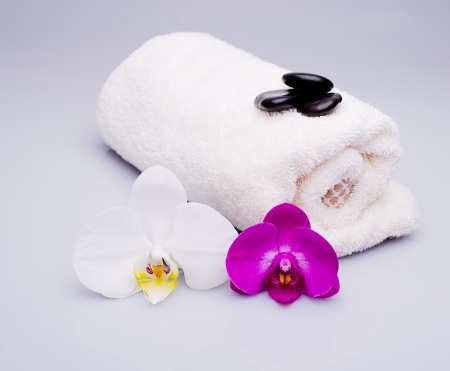 white and purple orchid, towel and massage stonesの写真素材