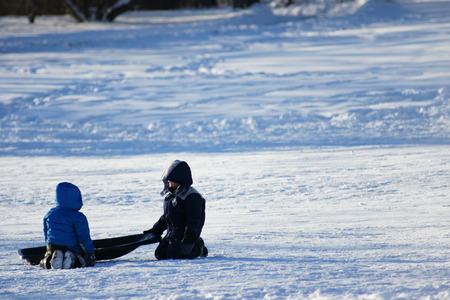 Snow sledding brothersの写真素材