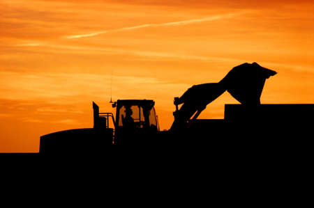 Industrial construction loader silhouette at sunrise or sunsetの写真素材