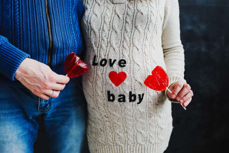 Pregnant wife with husband. Man touching belly of pregnant woman. Family couple waiting for baby.の写真素材