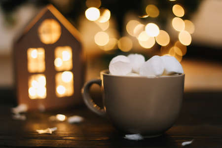 Christmas coffee cup with marshmallows. Still life on dark background. New Year's lights and decorations. Flat layの写真素材