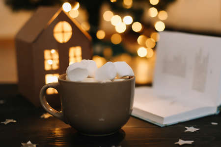 Coffee cup with marshmallows and a book on the table. Still life on dark background. Flat layの写真素材