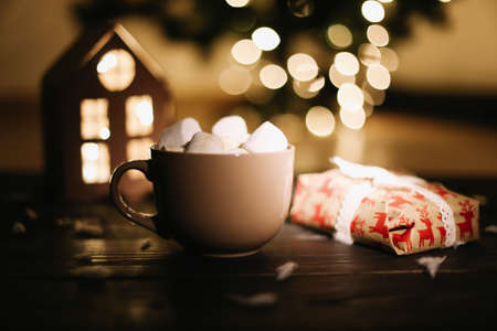 Christmas coffee cup with marshmallows. Still life on dark background. New Year's lights and decorations. Flat layの写真素材