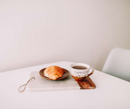 Mug of hot coffee and croissant. breakfast concept. good morningの写真素材