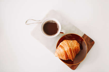 Mug of hot coffee and croissant. breakfast concept. good morningの写真素材