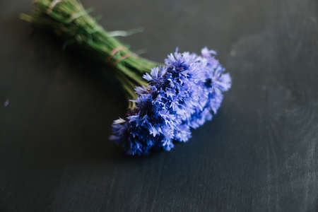 bouquet of cornflowers on a dark background. wedding details, bridal bouquet. wild flowersの写真素材
