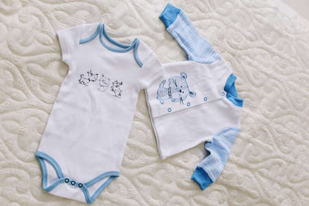 Baby's clothes on white background. Waiting for baby. Clothes for newborn boy on a pastel  background.の写真素材