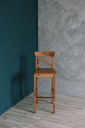 Wooden chair on gray wall background. minimalistic concept. Interior design.の写真素材