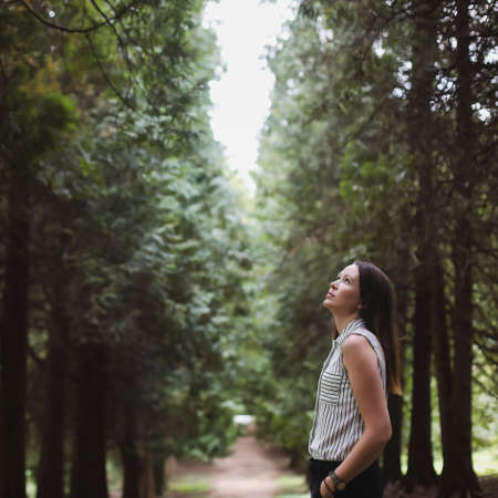 portrait of a girl looking up at a walk in the autumn forestの写真素材