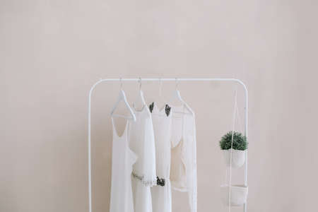 White dresses on a hanger. Set of women wedding dresses on a wooden hangers, fashion background, close up