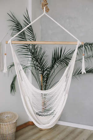 Cozy white hammock in living area, relaxing corner  at home. Minimal home interior design.の写真素材