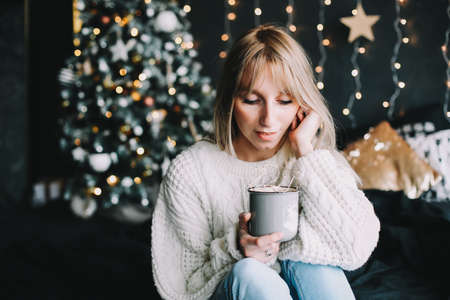 New Year portrait of a girl in beautiful interior. Girl with coffee in bed in the new year interior. Christmas and  New Year  conceptの写真素材