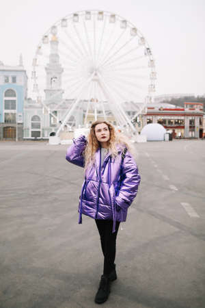A beautiful girl by the ferris wheel at Kontraktova Square in Kiev, Ukraine. December 4, 2018のeditorial素材