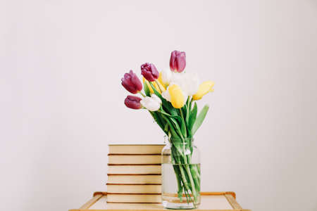 Bouquet of beautiful tulips. Mix of spring tulips flowers. Fresh Tulip Bouquet and books on white background. Spring flowers.の写真素材