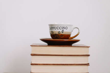Composition with stack of books and cup of coffee on white background. Sweet home.  flat lay