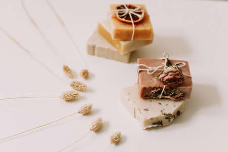 natural homemade soap bars with orange slices and flowers on white background. Spa concept, body...