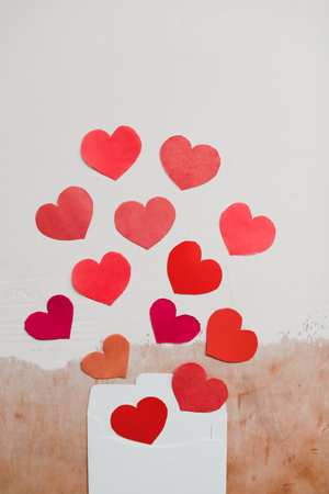 envelope with red paper hearts on a white background. Hearts take off from inside open envelope. Romantic love letter. Valentines Day concept. Flat lay, top view. banner, copy spaceの写真素材