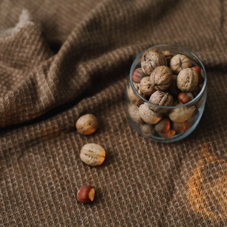 Mix of nuts in a jar on dark background. Walnuts and pine nuts. Top view. Copy space. Superfood,...