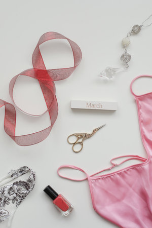 Flat lay composition of female underwear with a red ribbon and cosmetics on white background. top view, copy space. Concept Womens Day, March 8.の写真素材