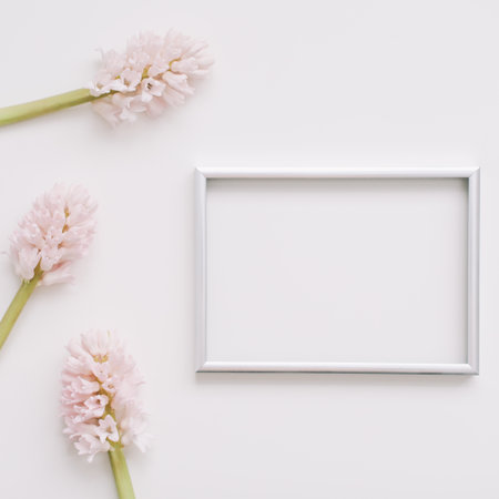 Wedding or birthday flat lay composition with pink flowers and blank photo frame, mockup, invitations. top view, copy space.の写真素材