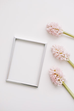 Wedding or birthday flat lay composition with pink flowers and blank photo frame, mockup, invitations. top view, copy space.の写真素材
