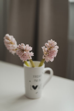 Spring flowers in cup on a table. Cozy home decor