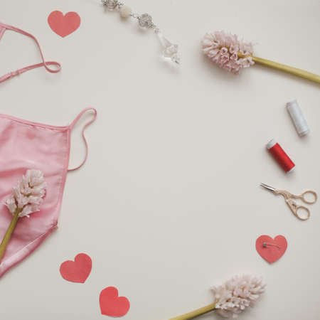 Flat lay with flowers, threads, textile, scissors and sewing accessories on white background. Sewing wokrshop, top view copy space.の写真素材