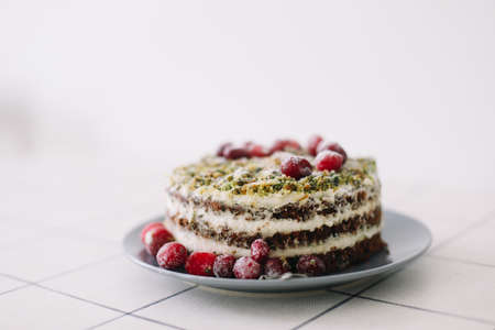 homemade cake with spinach and cream decorated with fresh cranberries on white table, diet breakfastの写真素材