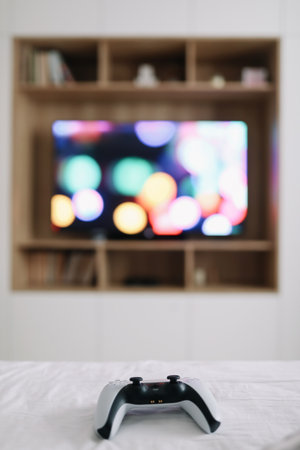Game controller, joystick on TV screen background. Playing game console, weekend at home, leisure lifestyle conceptの写真素材