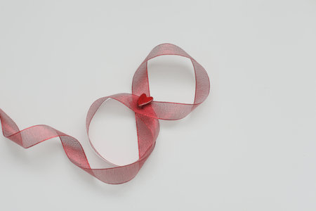 Figure eight of red ribbon on white background. International Womens Day concept.の写真素材