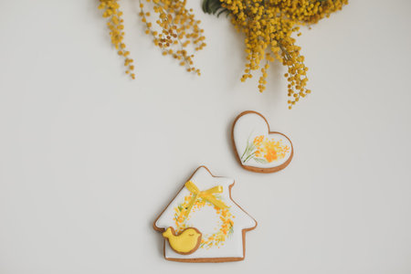 Easter gingerbread cookies and mimosa flowers on white background. top view copy space. Happy Easter conceptの写真素材